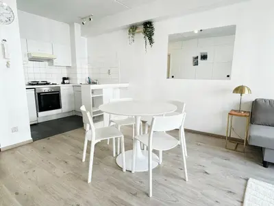 a white kitchen with a table and chairs in a room at Bright and Central Antwerp Apartments in Antwerp