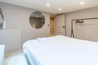 a white room with a bed and a mirror at Holiday Home in Antwerp in Antwerp