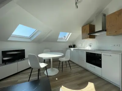 a kitchen with white cabinets and a table and chairs at Midi Station 3 in Brussels