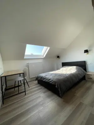 a bedroom with a bed and a desk and a window at Midi Station 3 in Brussels