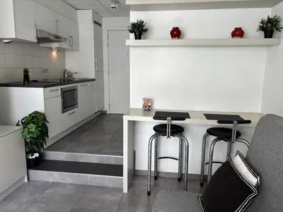 a kitchen with a table and two stools at Charming Studio in Central Brussels - Walk Everywhere! in Brussels