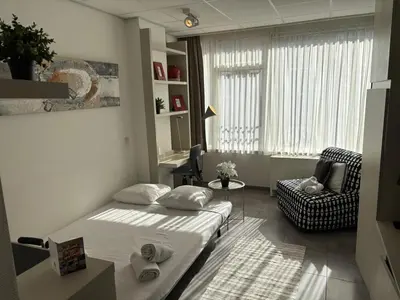 a small bedroom with a bed and a chair at Charming Studio in Central Brussels - Walk Everywhere! in Brussels