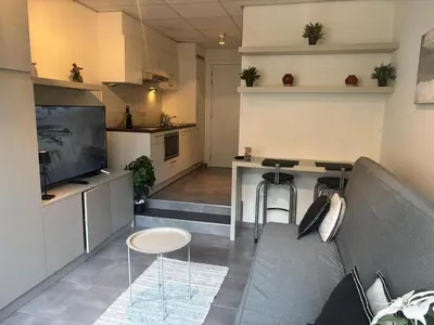 a living room with a couch and a kitchen at Charming Studio in Central Brussels - Walk Everywhere! in Brussels