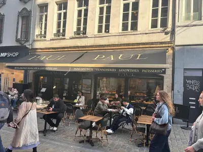 a group of people sitting at tables outside a restaurant at Charming Studio in Central Brussels - Walk Everywhere! in Brussels
