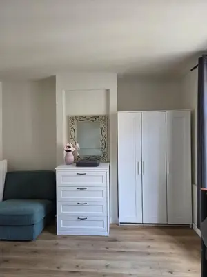 a living room with a white dresser and a blue couch at Apartamento en Gante in Ghent