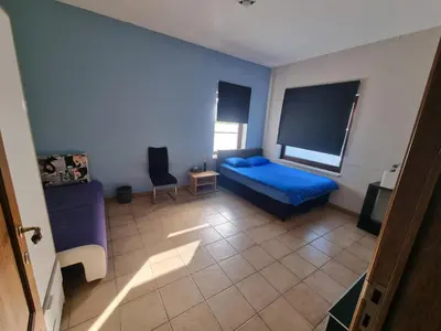 a bedroom with a blue bed and a chair at Beautiful 4 bedroom Villa close to Antwerp in Zwijndrecht