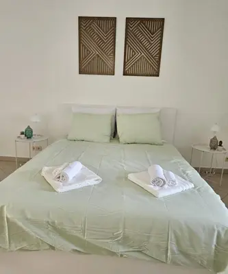 a white bed with towels on top of it at Proche du Centre de Bruxelles appartement 5 personnes in Brussels