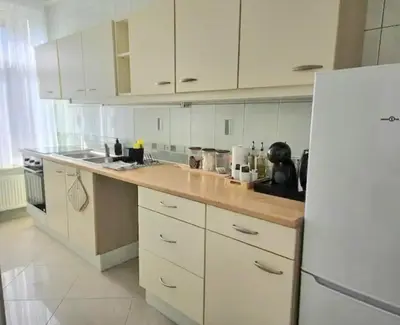 a kitchen with white cabinets and a white refrigerator at Proche du Centre de Bruxelles appartement 5 personnes in Brussels
