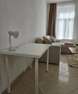 a white table in a living room with a couch at Proche du Centre de Bruxelles appartement 5 personnes in Brussels