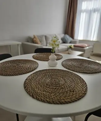 a white table with four brown circular plates on it at Proche du Centre de Bruxelles appartement 5 personnes in Brussels