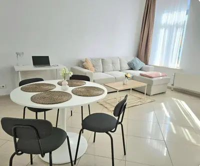 a living room with a table and chairs and a couch at Proche du Centre de Bruxelles appartement 5 personnes in Brussels