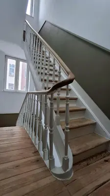 a staircase with a wooden floor and white rails at Sainte Catherine Apartments in Brussels