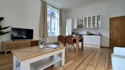 a living room with a table and a kitchen at Sainte Catherine Apartments in Brussels