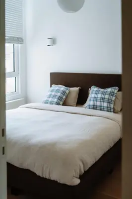 a bedroom with a large bed with blue pillows at La Petite Foret Design Flat in Antwerp City in Antwerp