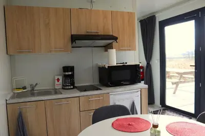 a kitchen with a sink and a table with chairs at Uniek privé natuurdomein voor 14 personen in Evergem