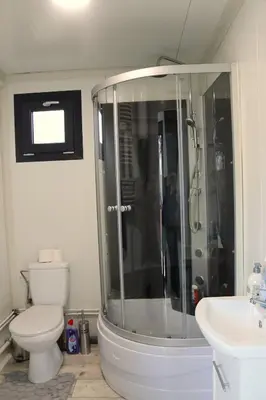a bathroom with a shower and a toilet and a sink at Uniek privé natuurdomein voor 14 personen in Evergem