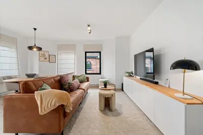 a living room with a couch and a tv at Comfort aan stadsrand Gent, vlakbij Natuurgebied in Ghent