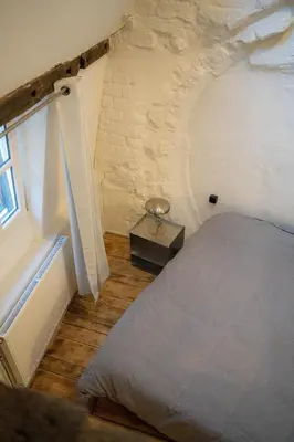 a bedroom with a bed in a stone wall at Royal Grand Place Loft in Brussels
