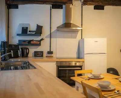 a kitchen with a table and a stove and a refrigerator at Royal Grand Place Loft in Brussels