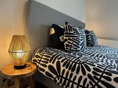 a bed with black and white pillows and a lamp at Downtown Spacious Design Duplex 3bedR in Brussels