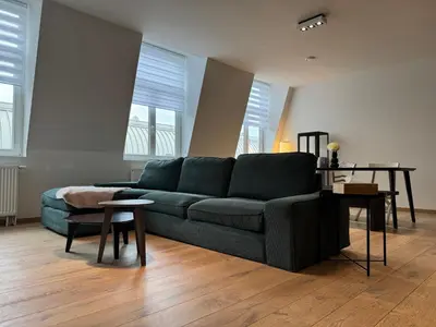 a living room with a couch and a table at Downtown Spacious Design Duplex 3bedR in Brussels