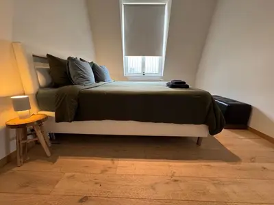 a bedroom with a large bed and a window at Downtown Spacious Design Duplex 3bedR in Brussels