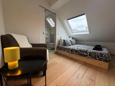 a living room with a bed and a chair at Downtown Spacious Design Duplex 3bedR in Brussels
