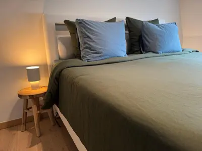 a bedroom with a bed with blue pillows and a table at Downtown Spacious Design Duplex 3bedR in Brussels
