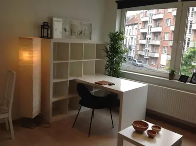 a desk and a chair in a room with a window at Hyppolite Metdepenningenstraat G in Ghent