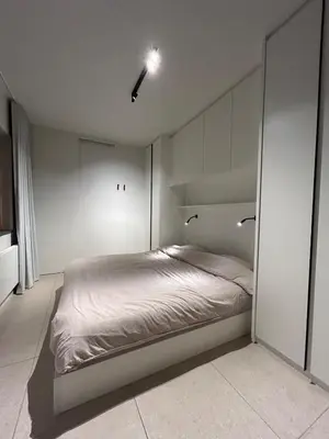 a bedroom with a bed in a white room at Studio Tzawel in Ghent