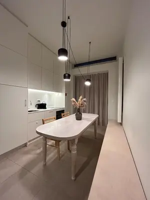 a white kitchen with a table in a room at Studio Tzawel in Ghent