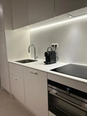 a white kitchen with a sink and a stove at Studio Tzawel in Ghent