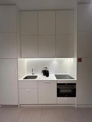 a kitchen with white cabinets and a sink at Studio Tzawel in Ghent