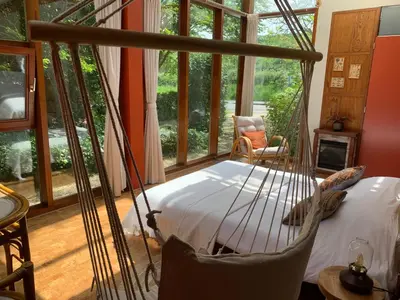 a bedroom with a hammock in a room with windows at The Bohemian House Melle in Melle