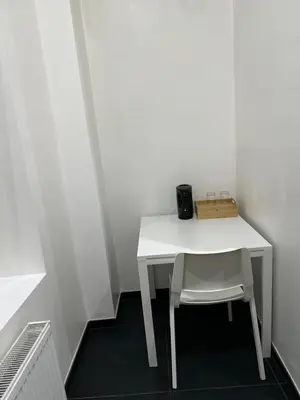 a white table and a chair in a room at Sweet apartment with belcon in Brussels