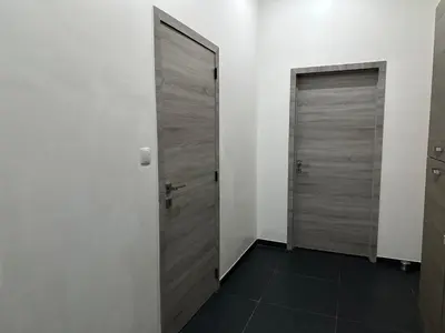 two wooden doors in a room with a tile floor at Sweet apartment with belcon in Brussels
