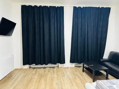 a living room with black curtains and a couch at Sweet apartment with belcon in Brussels