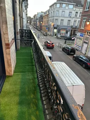 a balcony with green grass on a city street at Sweet apartment with belcon in Brussels