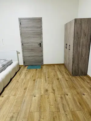 a bedroom with a wooden floor and a door at Sweet apartment with belcon in Brussels