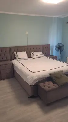a large bed in a room with a bed frame at Une Maison chaleureuse in Lebbeke
