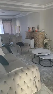 a living room with a couch and a table at Une Maison chaleureuse in Lebbeke
