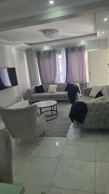a living room with couches and a table and a couch at Une Maison chaleureuse in Lebbeke