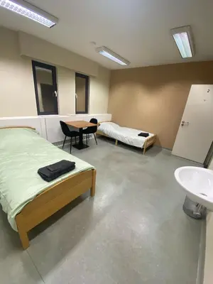 a room with two beds and a sink and a table at Stay Here in Erpe-Mere