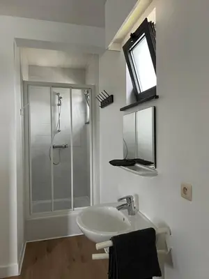 a white bathroom with a shower and a sink at Stay Here in Erpe-Mere