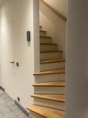 a stairway with wooden steps in a room at La maison de Nikolas in Oosterzele