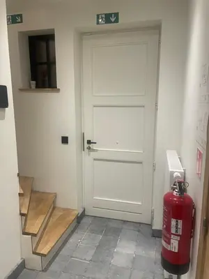 a fire hydrant sitting in front of a door at La maison de Nikolas in Oosterzele