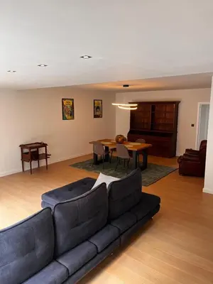 a living room with a couch and a table at Appartement ' Tintin Travels' in Geel