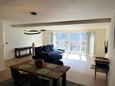 a living room with a table and a couch at Appartement ' Tintin Travels' in Geel