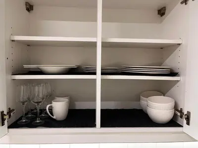 a white cabinet with plates and bowls and dishes at Appartement ' Tintin Travels' in Geel