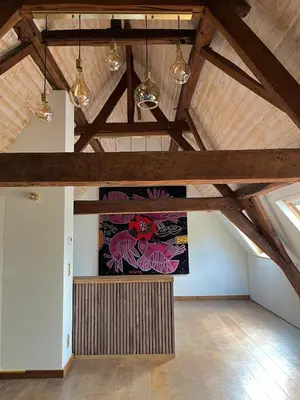 an attic room with a large painting on the wall at Sint-Catharina in Lier